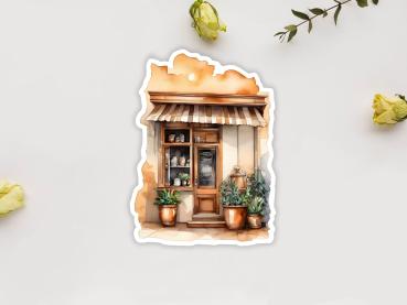 Preview: 8 Café Shop Sticker Set – Charmante kleine Cafés und Geschäfte Preview: Sticker mit einer rustikalen Geschäftsfassade im mediterranen Stil, mit gestreifter Markise, Pflanzen in Töpfen und Regalen voller Töpferwaren. Die Holztür und die dekorativen Elemente schaffen eine einladende Atmosphäre.